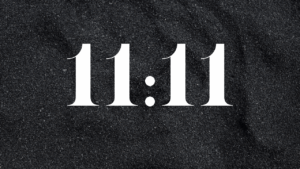 The numbers 11:11 displayed on a dark background represent the energy of the 11/11 Portal and its spiritual gateway for transformation.